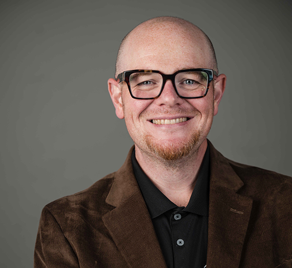 조디 존스가 노트북과 품에 안은 아들을 함께 보여주고 있습니다.